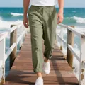 Men's loose sage green linen beach pants with drawstring waist shown on wooden pier - Army Green