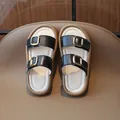 Stylish black children's slide sandals featuring gold metal buckles and thick tan soles - Size 21 (13.5cm) / Black