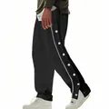 Detail view of men's black tear-away basketball pants with white snap buttons and side stripe. - S / Black