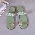 Close-up of green flat slide sandals with decorative pearl studs and pineapple rhinestone - 35 / Light Green