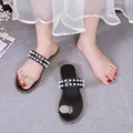 Close-up of black flat slides featuring pearl straps and pineapple rhinestone detail - 35 / Black