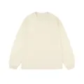 Front flat lay of a minimalist cream-colored long-sleeve cotton T-shirt with ribbed cuffs - Apricot