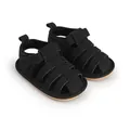 Detail van zwarte baby sandalen met zachte zolen, kooi-ontwerp en praktische klittenbandsluiting. - Zwart