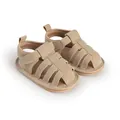 Close-up van beige babyzomersandalen met zachte zool en uitgesneden kooiontwerp. - Abrikoos