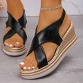 Close-up detail of stylish black criss-cross strap wedge sandals with golden platform heels - 35 / Black