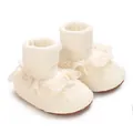 Detalle de cerca de zapatos blancos para bebé niña con encaje floral y volantes. - Beige