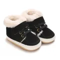Detailansicht warmer schwarzer Babyschuhe mit weißem Kunstfellfutter und Gummisohle. - Schwarz