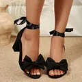 Close-up of elegant black high-heel sandals featuring decorative bows and satin ribbon ties - 35 / Black Style (01S)