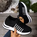 Close-up view of black fly-knit platform sneakers featuring stylish silver stripe accents - 36 / Black