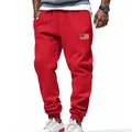 Detail of red men's joggers featuring an American flag patch and drawstring waist - S / Bottoms / Red