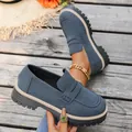 Close-up of blue suede platform loafers with thick soles and British style details - Blue