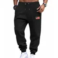 Close-up detail of black men's drawstring joggers featuring an American flag patch detail. - S / Bottoms / Black