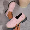 Detailed view of pink chunky platform loafers featuring classic British style and thick black soles - Pink