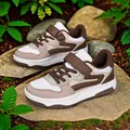 Baskets pour enfants en blocs de couleurs marron et beige sur des rochers naturels - Marron