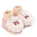 Detailed view of pink newborn baby sock shoes featuring lace trim and cherry embroidery - Pink