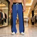 Men's blue and black color-blocked joggers with white drawstring in a mall setting - Royal Blue/Black
