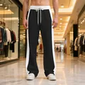 Detail view of men's heavyweight joggers with side stripes and relaxed straight leg - S / Bottoms / Black & White