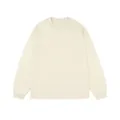 Detailed front view of a minimalist cream-colored long-sleeve cotton t-shirt for men - Apricot