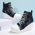 Close-up detail of women's camouflage high-top wedge sneakers with thick platform soles - 35 / Navy Blue