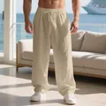 Close-up view of men's loose linen trousers with casual drawstring waist in khaki - Light Khaki