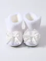 Detailansicht weißer, fleecegefütterter Baby-Lauflernschuhe mit dekorativen Spitzenschleifen - Weiß