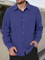 Detailopname van een casual blauw herenoverhemd met lange mouwen en een handige borstzak - S / Tops / Blauw