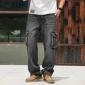 Men's dark gray wide-leg cargo denim jeans shown in a lifestyle outdoor setting - Black and Gray