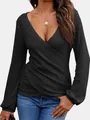 Detailaufnahme des schwarzen Wickelpullovers mit Waffelstrickmuster und tiefem V-Ausschnitt - Schwarz