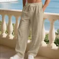 Macro view of khaki linen men's trousers featuring drawstring waist and pleated details - S / Bottoms / Light Khaki