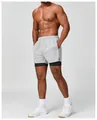Close-up detail of men's grey 2-in-1 quick-dry sports shorts worn by an athletic model - S / Bottoms / White