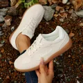 Close-up view of retro cream women's German army trainer sneakers on stone ground - 35 / Beige