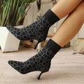 Detail of black pointed-toe stretch boots with geometric pattern and thin high heels. - 36 / Black