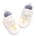 Close-up of white baptism baby shoes with golden embroidered cross detail and velcro strap. - Insole Length 11cm / Gold Cross Embroidery