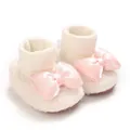 Close-up of white fleece baby shoes featuring a decorative pink satin bow - Beige