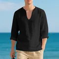 Detalle de una camiseta casual de manga larga de lino negro con cuello en V para hombre en la playa - Negro