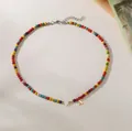 Detailed view of colorful bead necklace featuring a heart charm and golden letter A pendant. - Letter A