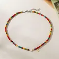 Detailed view of a colorful beaded necklace with a white heart and a golden letter J pendant. - Letter J