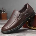 Dunkelbraune Herren-Slipper aus Leder mit strukturierter Oberfläche und Gummisohle - Braun