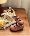 Detailaufnahme von eleganten rosa Retro-Lederschuhen für Kleinkinder auf einem rustikalen Holztisch - Größe 36 Innenlänge 22 / Rosa