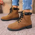 Detailed macro view of women's brown suede lace-up Martin boots with black collar - Turmeric