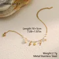 Macro detail of a stainless steel bracelet featuring dainty shell and pearl charms - Gold Leaf Charm (NMSB-L413-1) / 18K Gold