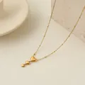 Dettaglio ravvicinato di una collana in acciaio dorato con tre ciondoli a forma di cuore. - Stile Nappa a Triplo Cuore (NMSN-L439-2) / Oro 18K / Oro