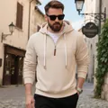 Primer plano de hombre con sudadera beige gruesa con capucha y media cremallera en calle - Albaricoque