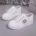 Detailed view of white platform sneakers with elegant rhinestone buckle. - 36 / White