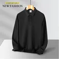 Professional front view of a minimalist long-sleeved black polo shirt on a wooden hanger - S / Tops / Black