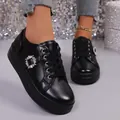 Close-up detail of stylish black leather platform shoes featuring a sparkling crystal buckle. - 36 / Black