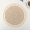 Macro view of round cotton woven placemat with elegant beige tassel fringe details. - 12-Piece Set / Beige
