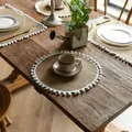 Rustic round jute placemat with white pom-pom fringe details on a vintage wooden table - 38cm Round / White Fur Ball