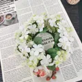 Close-up van kunstmatige witte wilde bloemenkrans op een vintage krantenachtergrond. - Wit