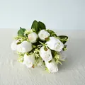 Detalle de la textura de los pétalos y el follaje de un ramo de rosas blancas falsas. - Crema